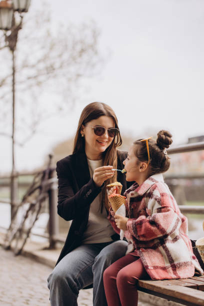 istock Mother and daughter enjoying ice cream cones outdoors in urban setting 2192363972