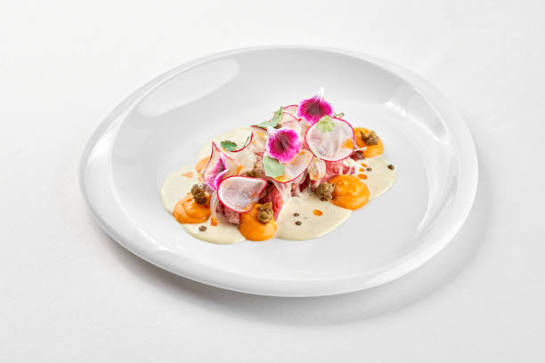 istock A gourmet dish featuring a delicate piece of venison steak, surrounded by a vibrant arrangement of fresh vegetables and edible flowers 2192369258