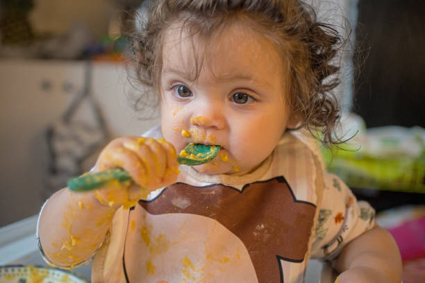 istock Toddler Eating Messy Meal with Spoon 2192372190