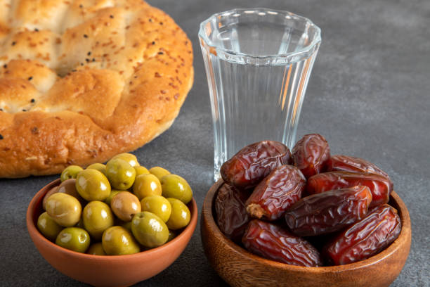 istock Dates fruit, green olives, Ramadan pita, and water for the iftar table 2192372302