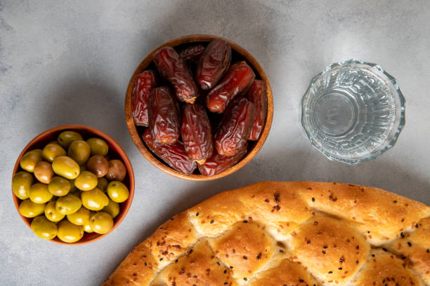 istock Dates fruit, green olives, Ramadan pita, and water for the iftar table 2192372347