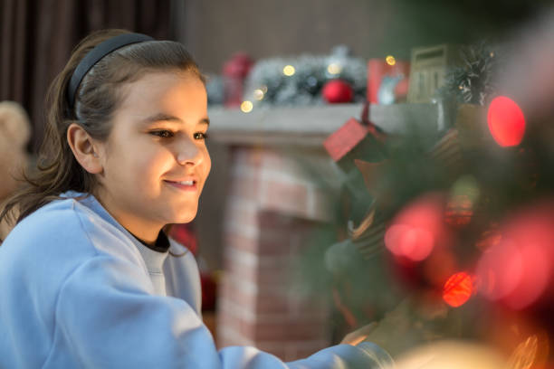 Excited boy pulling gifts from a stocking by the fireplace