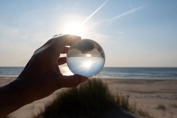 istock Beach and sea reflected in a ball in a human hand 2192372772