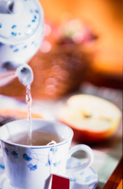 teapot pouring hot water cup of apple tea