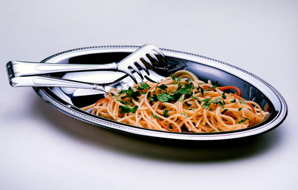 pasta served in a stainless steel bowl, white background