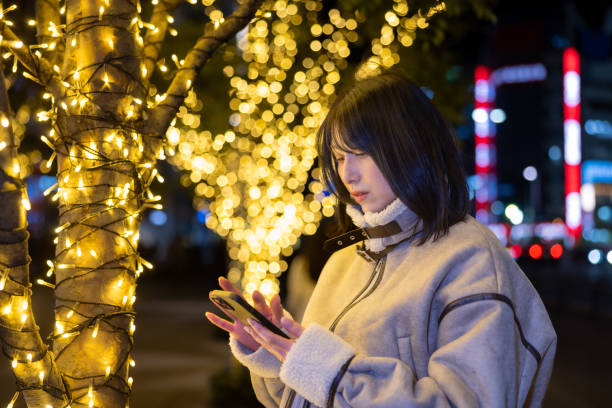 istock Young woman using smart phone at Christmas night 2192376458