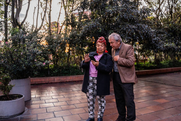Senior couple using mobile phone outdoors