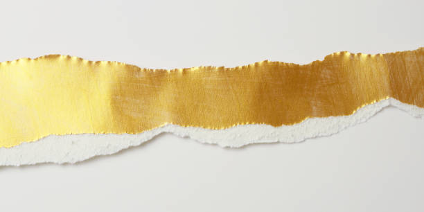 istock Gold torn pieces of texture paper on light beige copy space horizontal long background. 2192380151