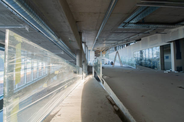 istock A captivating view of a modern business building under construction, showcasing its raw industrial interior with exposed steel beams and concrete walls bathed in the warm, golden hues of a sunset 2192386678