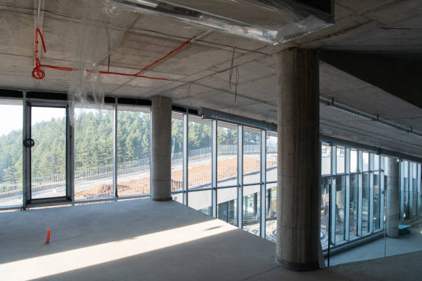 istock A captivating view of a modern business building under construction, showcasing its raw industrial interior with exposed steel beams and concrete walls bathed in the warm, golden hues of a sunset 2192388009