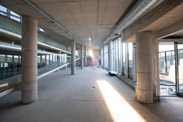 istock A captivating view of a modern business building under construction, showcasing its raw industrial interior with exposed steel beams and concrete walls bathed in the warm, golden hues of a sunset 2192389038