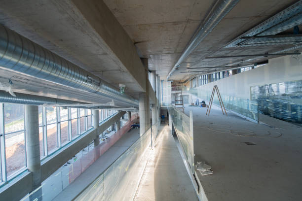 istock A captivating view of a modern business building under construction, showcasing its raw industrial interior with exposed steel beams and concrete walls bathed in the warm, golden hues of a sunset 2192389595
