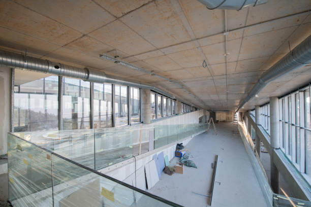 istock A captivating view of a modern business building under construction, showcasing its raw industrial interior with exposed steel beams and concrete walls bathed in the warm, golden hues of a sunset 2192390246