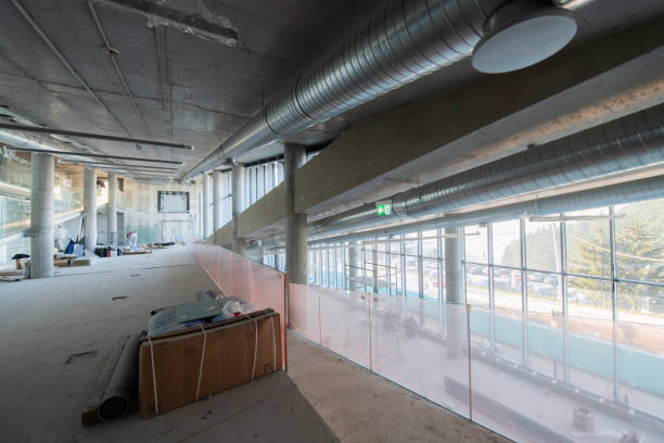 istock A captivating view of a modern business building under construction, showcasing its raw industrial interior with exposed steel beams and concrete walls bathed in the warm, golden hues of a sunset 2192390314