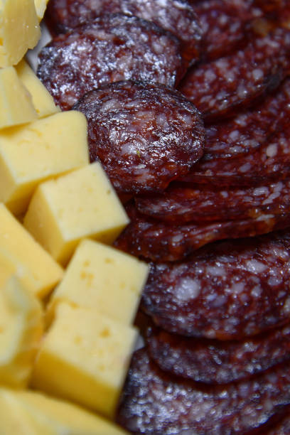 Detail of a charcuterie board with focus on cheese and meat.