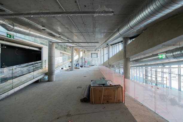 istock A captivating view of a modern business building under construction, showcasing its raw industrial interior with exposed steel beams and concrete walls bathed in the warm, golden hues of a sunset 2192390816