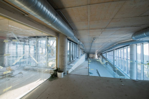 A captivating view of a modern business building under construction, showcasing its raw industrial interior with exposed steel beams and concrete walls bathed in the warm, golden hues of a sunset