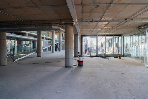 istock A captivating view of a modern business building under construction, showcasing its raw industrial interior with exposed steel beams and concrete walls bathed in the warm, golden hues of a sunset 2192392007