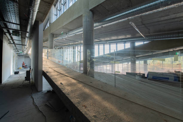 istock A captivating view of a modern business building under construction, showcasing its raw industrial interior with exposed steel beams and concrete walls bathed in the warm, golden hues of a sunset 2192392053