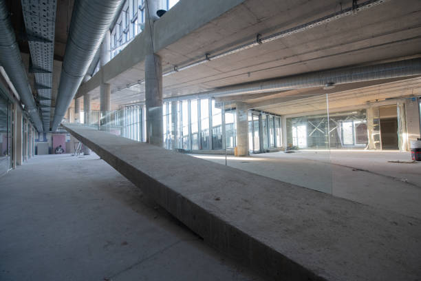 istock A captivating view of a modern business building under construction, showcasing its raw industrial interior with exposed steel beams and concrete walls bathed in the warm, golden hues of a sunset 2192392108