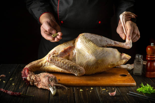istock Adding dry, aromatic spices to a turkey carcass by the chef's hands. An idea for preparing aromatic poultry meat on the kitchen table. Asian cuisine 2192395743