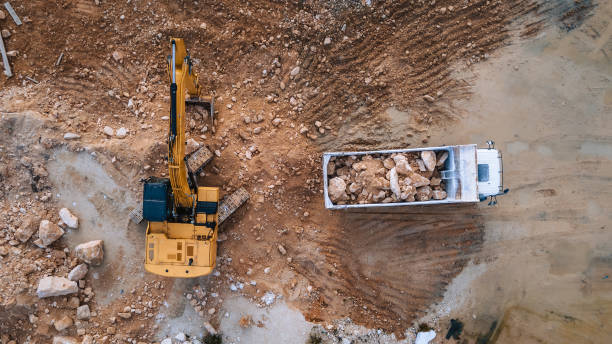 Heavy Machinery at Work, Excavator Loading Rocks into a Truck