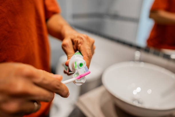 istock Close-up of man putting toothpaste on toothbrush 2192400199