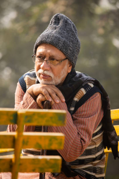 istock Old thoughtful sad man sitting on bench in garden 2192401869