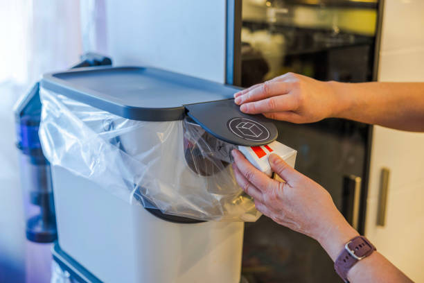 istock Woman's hands placing carton packaging into modern recycling bin with plastic bag and smart lid in clean kitchen interior. Sweden. 2192405326