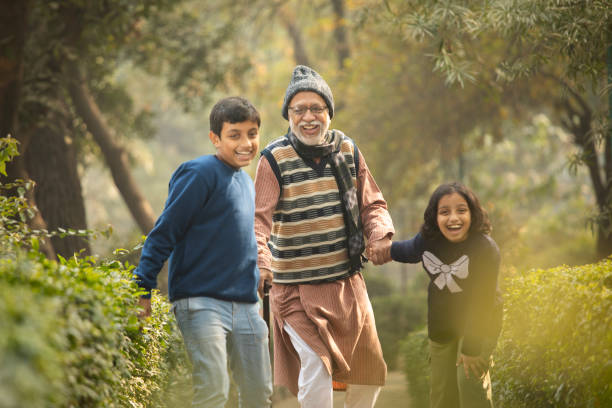 istock Happy grandchild pulling their grandfather while walking at park 2192406461