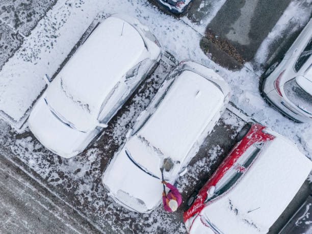 istock Removing snow from car on parking lot 2192408195
