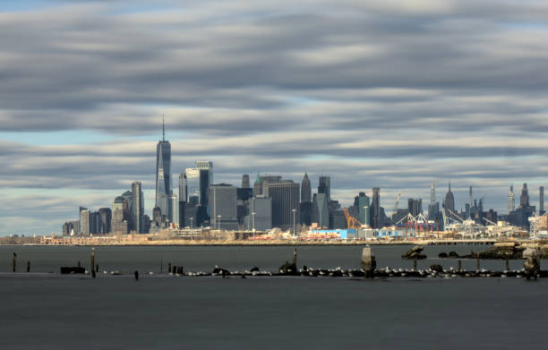 istock manhattan new york city skyline view from bush terminal park brookyn (downtown financial center skyscraper) dramatic sky clouds light sunset waterfront harbor river pier long exposure travel tourism 2192409082