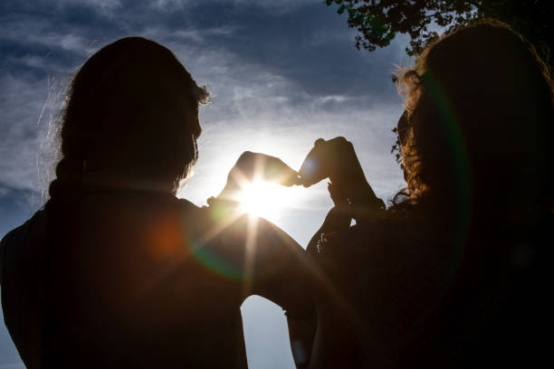 A HeartShaped Gesture Silhouette Elegantly Set Against the Beautiful Sunlight at Dusk,