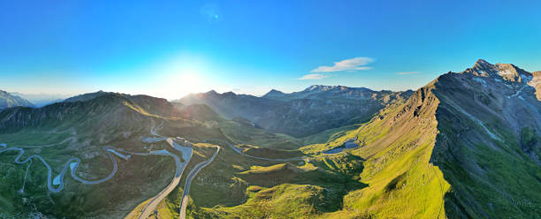istock Sunlit Alpine Landscape with Lush Green Valleys and Rugged Peaks 2192410572