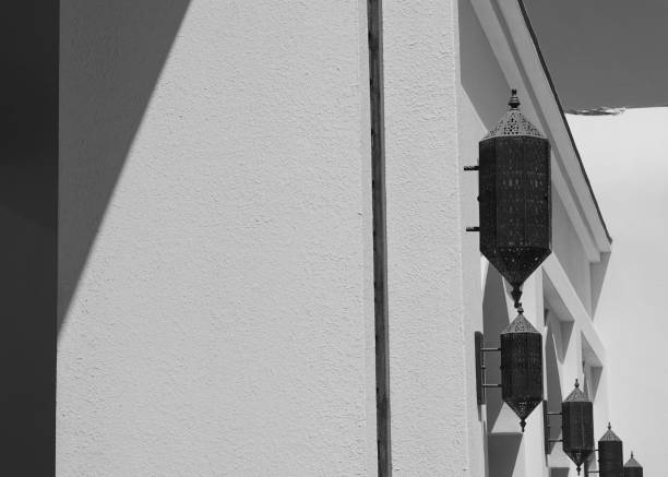Ancient black metal wrought iron lantern hanging on the stone wall. Vintage wrought iron lantern in historical house in old town. Travel photo, nobody, copy space