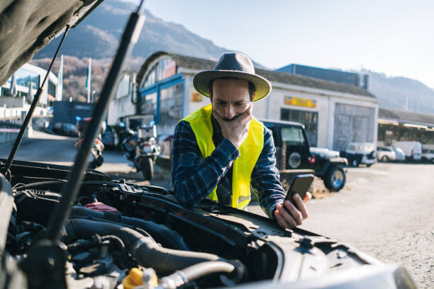 istock Man uses mobile phone near vehicle break down 2192424000