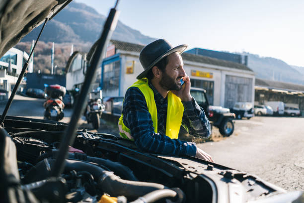 istock Man uses mobile phone near vehicle break down 2192424001