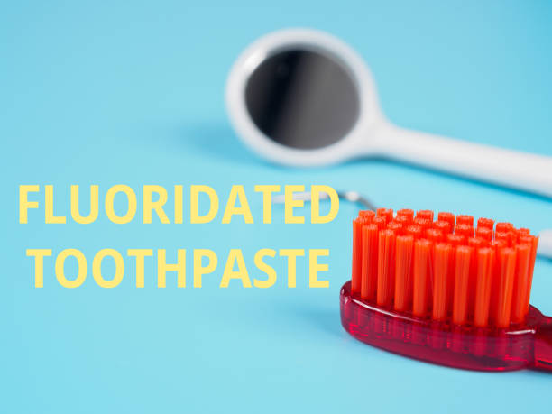 istock FLUORIDATED TOOTHPASTE inscription title on dental background 2192424082