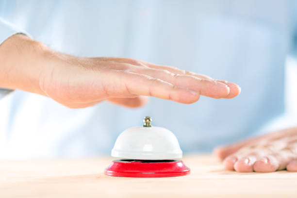 Service concept. Businessman hand above red hotel service bell