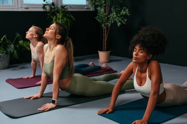 istock Young women practicing bhujangasana or cobra pose during yoga class 2192441129