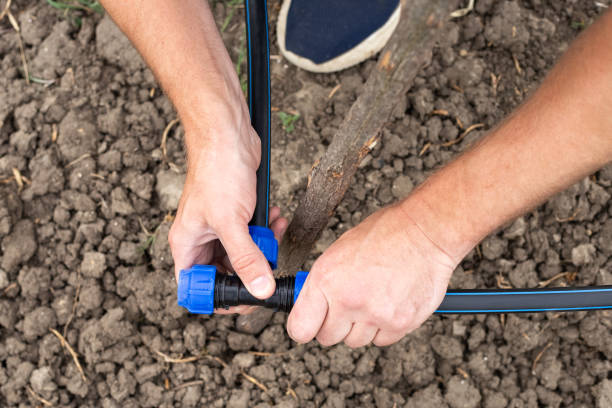 istock Fastening and connecting HDPE pipes with a fitting. A man installs an automatic drip irrigation system for his garden 2192441230