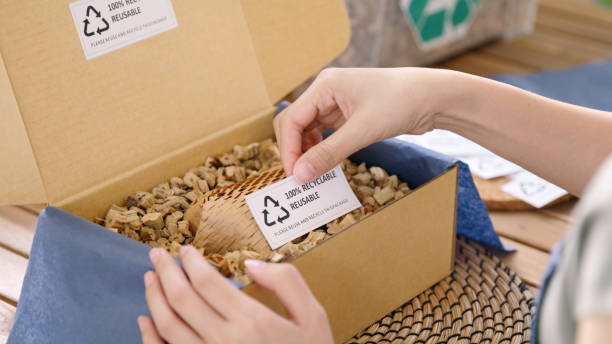 istock Eco vendor go green packaging parcel carton box in net zero waste store asian seller retail shop. Earth care day small SME owner asia people wrap reuse brown paper pack gift reduce plastic free order. 2192443321