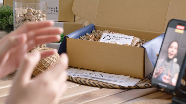 istock SME owner go green net zero retail store live stream talk on phone showing eco care plastic free packaging box. Asia people young woman record video on tiktok IG reel instagram shop happy side hustle. 2192443597