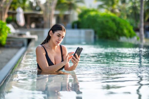 istock Woman in the pool reading her social networks 2192445484
