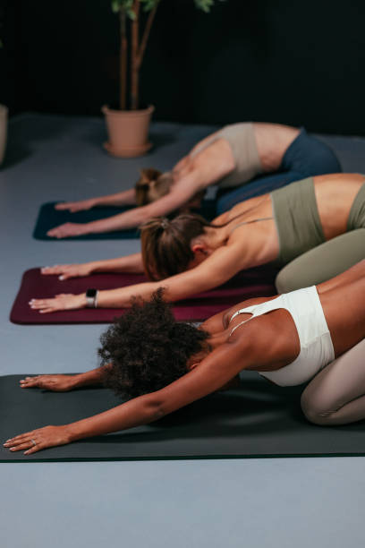 istock Young women practicing child's pose yoga on mats in studio 2192448645