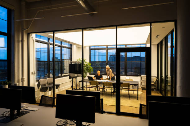 Businessman and woman working together at desk, working overtime