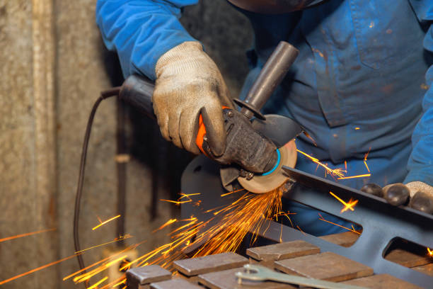 istock Craftsman grinding metal in workshop during evening, sparks flying around 2192449663