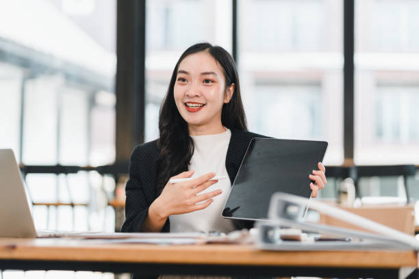 istock woman in modern office setting is presenting with tablet, showcasing her ideas confidently. Her engaging expression reflects enthusiasm and professionalism 2192451643