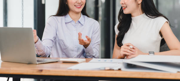 istock Two women engaged in discussion at modern office desk, sharing ideas and collaborating on project. Their expressions reflect enthusiasm and teamwork 2192451848