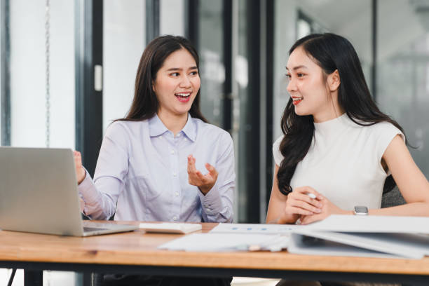 istock Two women engaged in lively discussion at modern office desk, sharing ideas and collaborating on project. Their expressions reflect enthusiasm and teamwork 2192451869